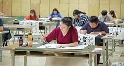 在書法比賽現場,參賽者個個屏氣凝神,將全部注意力灌注在筆尖上。