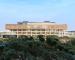 臺南市立圖書館新總館外觀,隱身樹林的淡金色格柵褶褶生輝