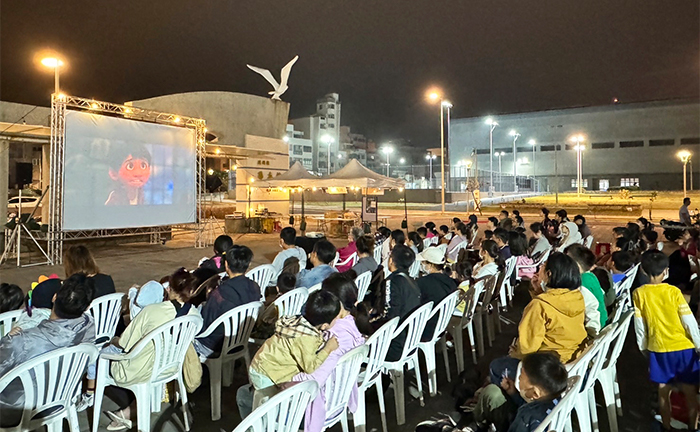 澎湖縣圖舉辦「星空電影院」萬聖節特別場,眾多家庭在圖書館戶外廣場共度美好夜晚。