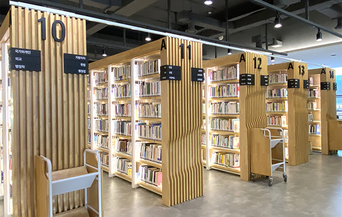 木質書架頂端加裝白色金屬條固定,兼具美感與防震效果。