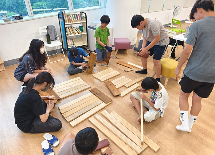 專業講師帶領青少年做木工，釘製「仿生高架菜箱」。